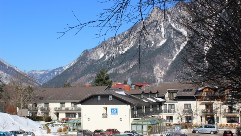 Exterior view, © Flackl-Wirt Exterior view of a building against a mountain backdrop with snow-covered peaks and a blue sky.