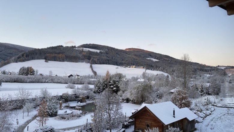 Outlook Molzbachhof, © Peter Pichler Winter landscape with snow-covered hills and a wooden house in the foreground.
