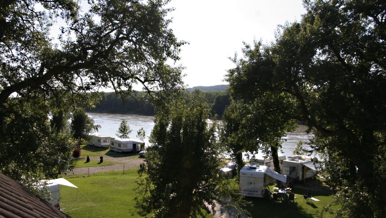 Campsite, © Szilágyi Campsite by the river with caravans and trees.