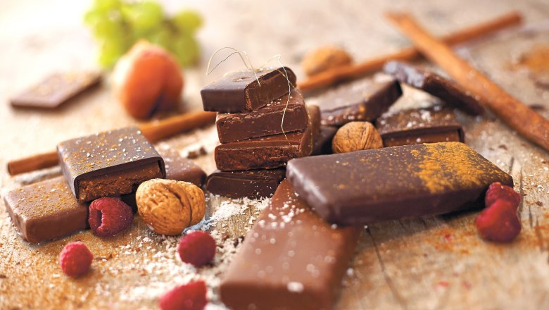 STYX chocolate, © Styx Naturkosmetic GmbH Various pieces of chocolate with nuts and raspberries on a table.