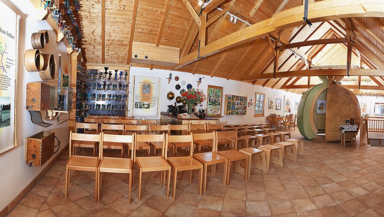 Poppy Museum, © Waldviertler Mohnhof Interior view of a museum with wooden chairs, information boards and exhibits on the walls.