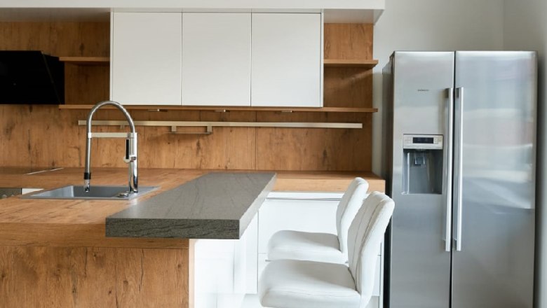 Lounge area, © Eugenia Husti Modern kitchen with wood and white tones, bar stools and stainless steel fridge.