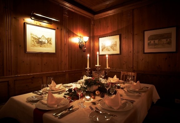 festively decorated wine taverns, © Steigenberger Hotel and SPa Festively laid table in a cozy wine bar with candlelight and wooden walls.