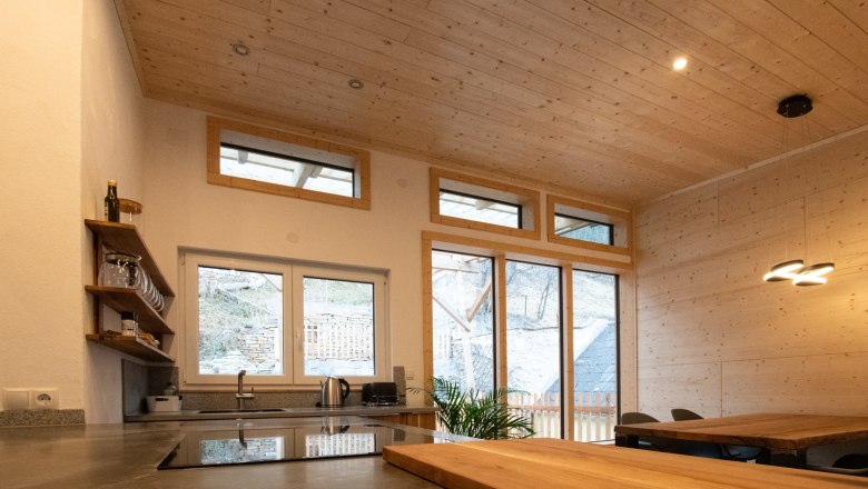 Open kitchen, © Silbersberg Cottage Modern kitchen with wooden ceiling and large windows.