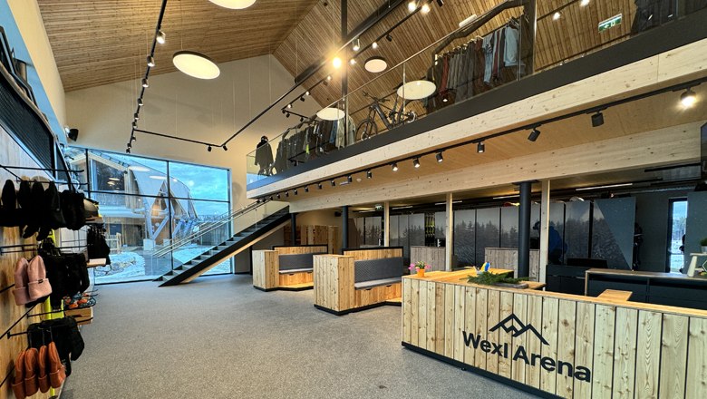 "Wexl Base" - service center, winter outdoor school, rental and store, © Wexl Arena St. Corona am Wechsel Interior view of the Wexl Base service center with wooden furniture and a staircase.