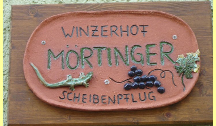 Winery, © Familie Mörtinger Sign with the inscription 'Winzerhof Mörtinger Scheibenpflug' and decorations of grapes and a lizard.