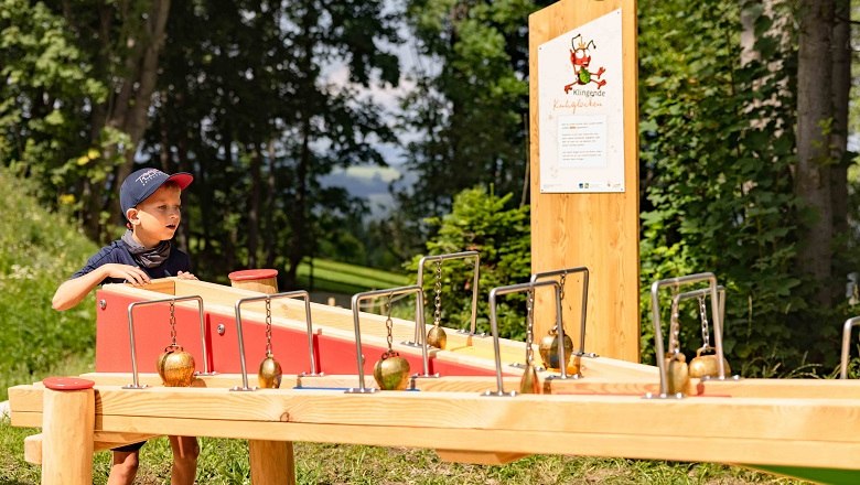 Ball track, © Wexl Arena St. Corona am Wechsel A boy plays on a wooden marble run outdoors.