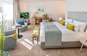 Golf resort Haugschlag, © by Haugschlag Modern hotel room with large bed, seating area and desk.