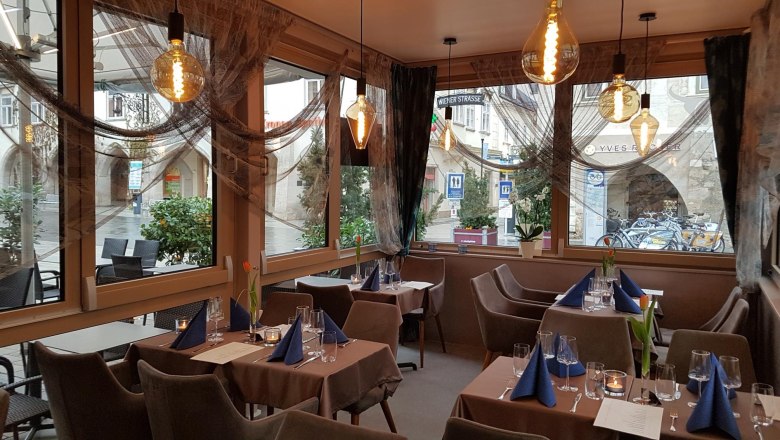 Reef & Beef inside, © Piroska Weiss Interior view of a stylishly furnished restaurant with set tables and large windows.