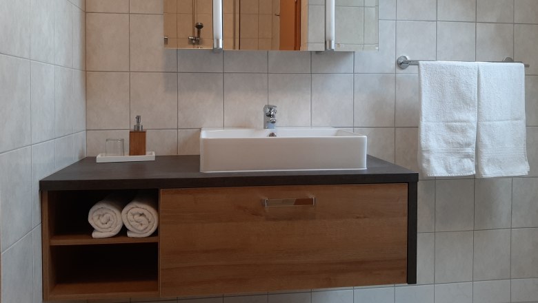 Bathroom, © Gerhard Auer Modern bathroom with washbasin, towels and mirror.
