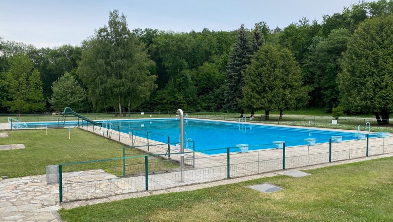 Sonnenwaldbad Pulkau, © Stadtgemeinde Pulkau An empty outdoor pool with a large swimming pool, surrounded by trees and lawns.