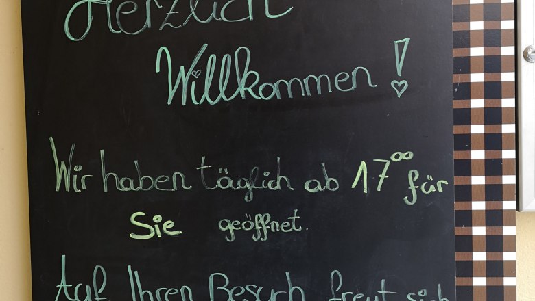 Kalmuck welcome board, © Donau NÖ Tourismus Plaque with welcoming text in front of a wine bar called Kalmuck.