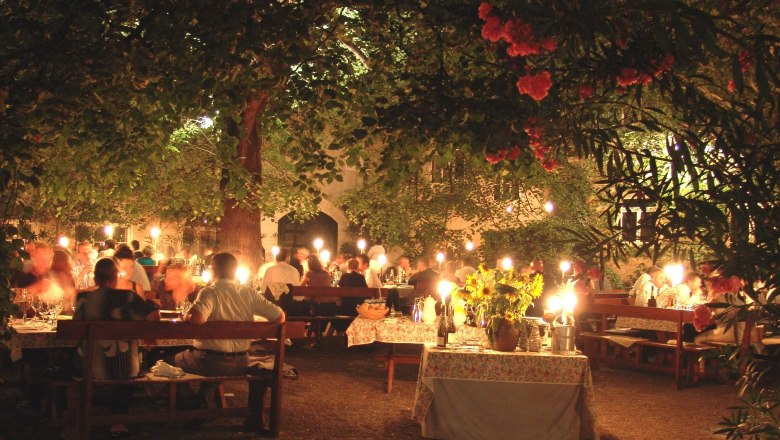 Under the lime tree, © Anna Lun Dinner outside under a tree with candlelight and lots of guests.