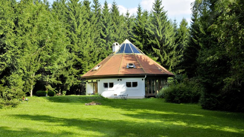 Seminar house DIE LICHTUNG, © Seminarhaus DIE LICHTUNG A round house with a pyramid roof in the middle of a forest.