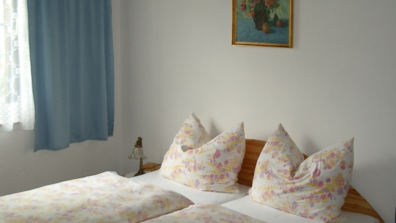 Apartments Maria Slavik, © Slavik Bedroom with double bed, blue curtains and flower picture on the wall.