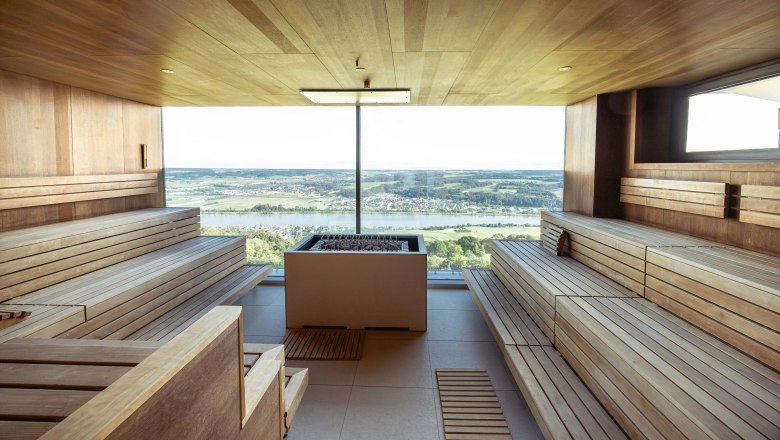 Hotel Schachner, © Niederösterreich Werbung / Maximilian Pawlikowsky Interior view of a sauna with a panoramic view of a landscape.