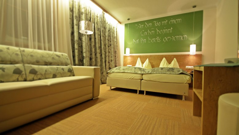 Cozy guest rooms, © Forellenhof, Franz Zwickl Cozy guest room with double bed, sofa and decorative curtains.