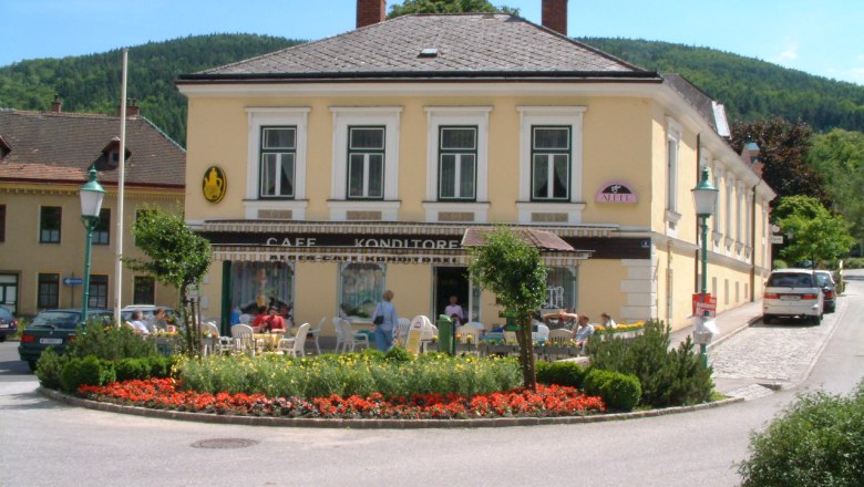 Café Konditorei Alber in Payerbach, © Café Konditorei Alber Café Konditorei Alber in Payerbach with outdoor area and flowers in front.