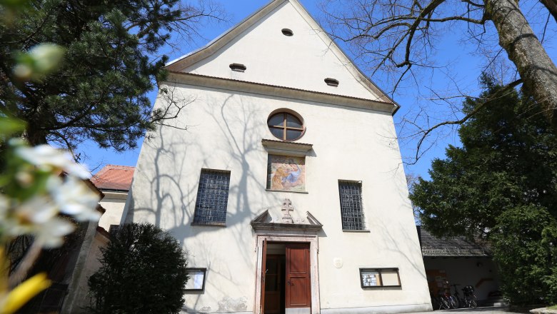Capuchin Church, © schwarz-koenig.at Facade of the Capuchin church with entrance and windows, surrounded by trees.
