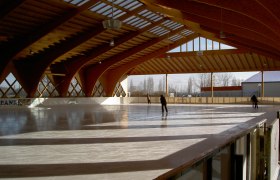 Covered artificial ice rink, © Kunsteisbahn Traiskirchen Covered artificial ice rink with wooden structure and skaters.
