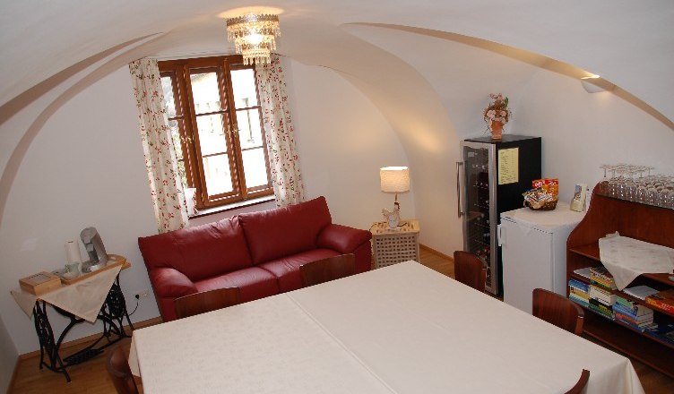 Lounge Schneiderstüberl, © Annemarie Heller Cozy lounge with red sofa, table, fridge and games.