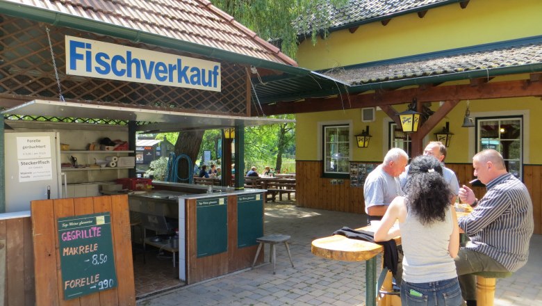 Fish sale, © Urani A fish stall with people eating at a table.