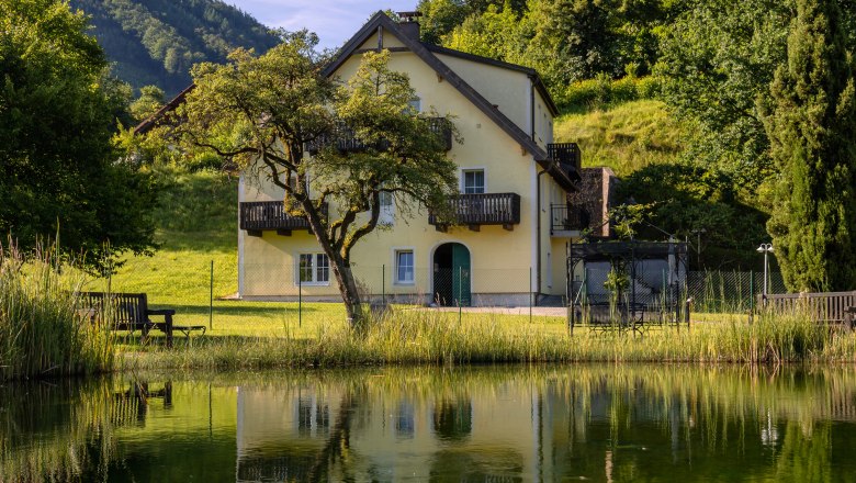 Hotel ResidenzWachau, © Niederösterreich Werbung / Maximilian Pawlikowsky Yellow house with balcony, surrounded by trees, reflected in a pond.