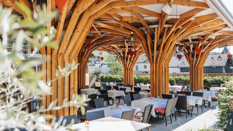 Modern, shady guest garden, © Niederösterreich Werbung/David Schreiber Modern guest garden with wooden construction and covered tables.