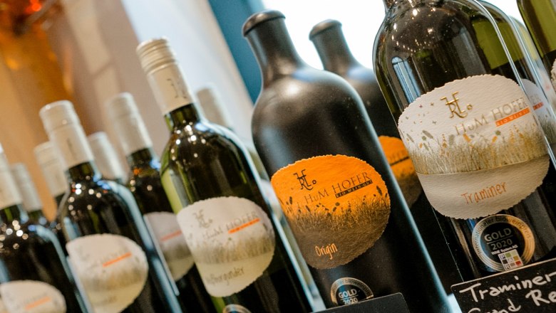 Wide range of wines, © Astrid Bartl Close-up of wine bottles with Hum Hofer brand labels.