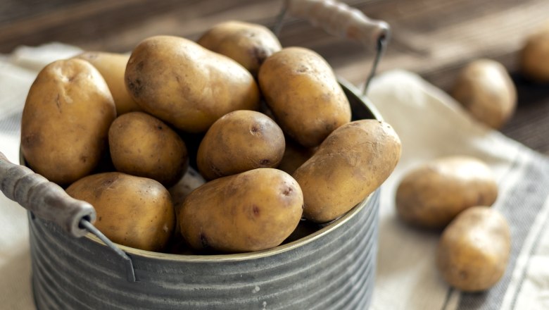 Potatoes, © Fam. Luckerbauer A pot filled with potatoes on a cloth, in the background even more potatoes.