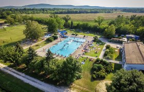 Seefeld-Kadolz leisure center, © © Marktgemeinde Seefeld-Kadolz Aerial view of an outdoor pool with swimming pool, slide and sunbathing area, surrounded by trees and fields.