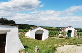 Maulavern wine cellar lane in Zellerndorf, © Weinstraße Weinviertel Wine cellar in Zellerndorf, surrounded by vineyards and blue skies.