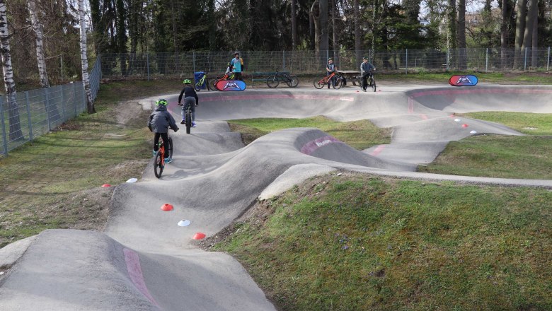 Pump track Neunkirchen, © Stadtgemeinde Neunkirchen Children ride bikes on a pump track.