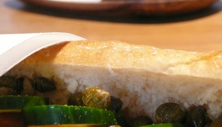 Snacks, © Süd - das Kulturcafé Close-up of a sandwich with cucumber, tomatoes and capers.