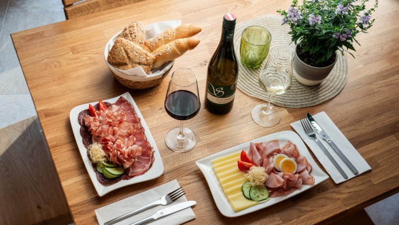 Regional delicacies lovingly prepared, © Martin Mathes A table with regional delicacies: Cold cuts, cheese, bread, red and white wine.