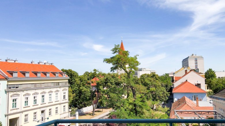 View of the countryside, © Apartment am Stadtpark Urban view with trees and buildings under a blue sky.