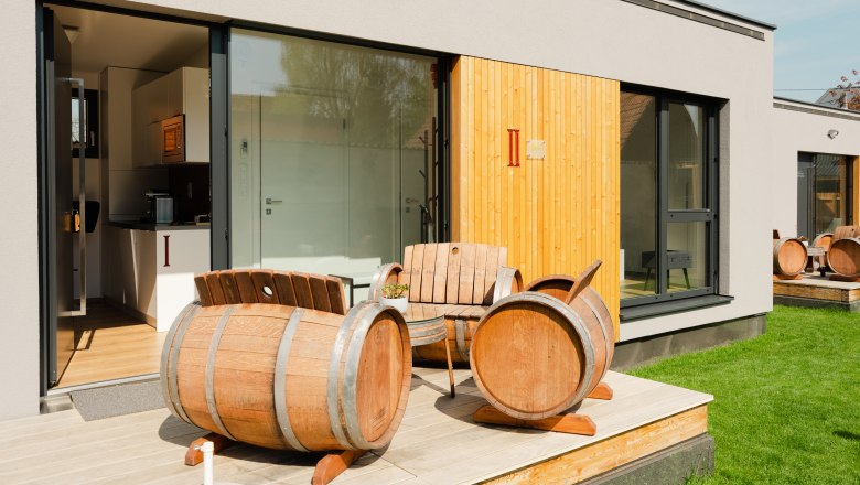 Ipsmiller Apartments, © Michael Reidinger Modern terrace with wine barrel furniture in front of an apartment.