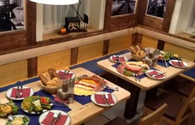 Station brewery, © Bahnhofsbräu Styx A table set in a rustic restaurant with bread, cold cuts and salads.