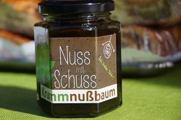 7-nut-with-shot, © Johann Peham A glass with the inscription 'Nuss mit Schuss' on a green cloth.