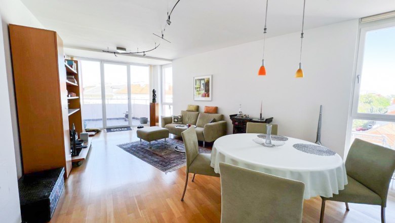 Apartment at the city park, © Apartment am Stadtpark Modern living room with wooden floor, dining table and large windows.