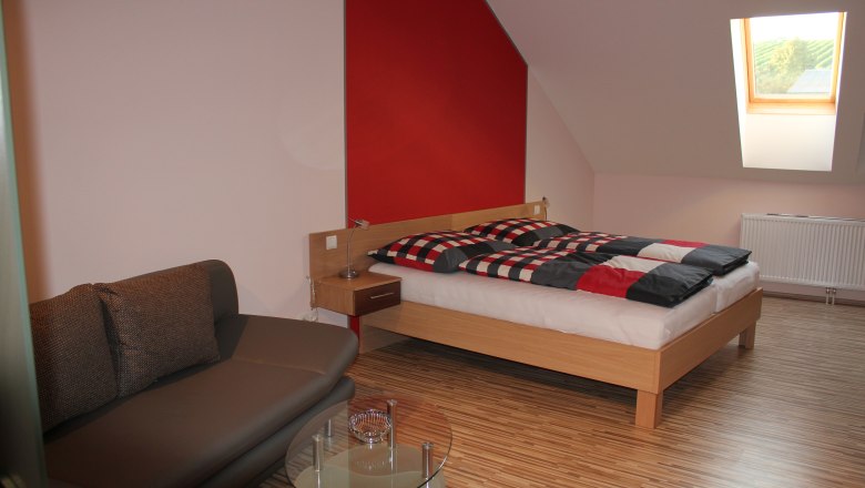 Guesthouse Woditschka, © Fam. Woditschka Modern furnished guest room with bed, sofa and skylight.