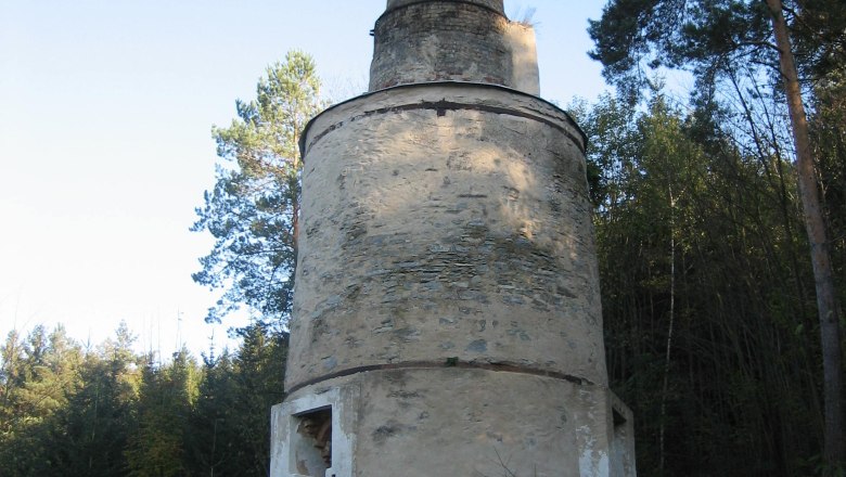 Municipality of Japons, © Gemeinde Japons An old, round stone chimney in a wooded area with an information board.
