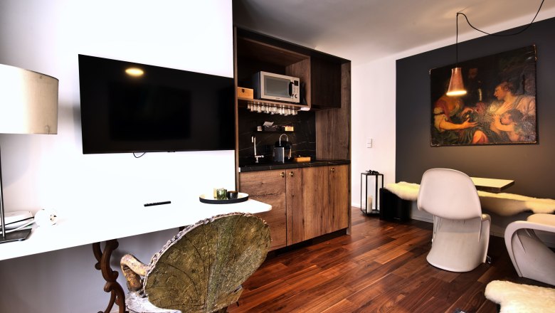 Kitchen unit Top 2, © Daniela Sinadinoska Modern kitchen with wooden elements, flat screen TV and dining area.