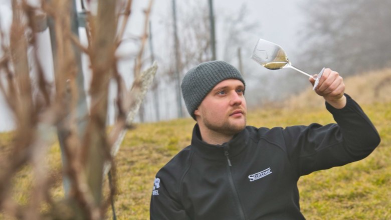 The winegrower, © Weinbau Stuttner A man sits in the vineyard and contemplates a glass of wine.