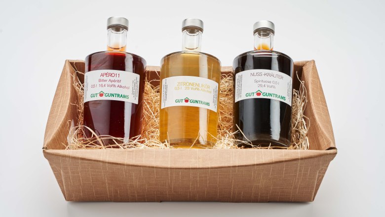Gift, © Gut Guntrams Three bottles of liqueurs in a gift box.