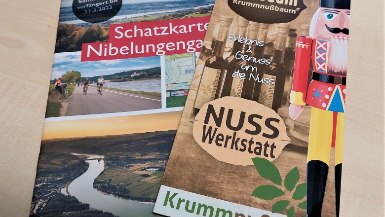 nusseum-season-opening-2022, © Johann Peham Two brochures on a table: one about the Nibelungengau treasure map and one about the Nusseum Krummnußbaum.