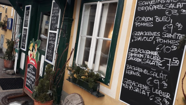 Stiegenwirtshaus Gloggnitz, © Stiegenwirtshaus/Stummer Entrance to a pub with several boards showing food and prices.