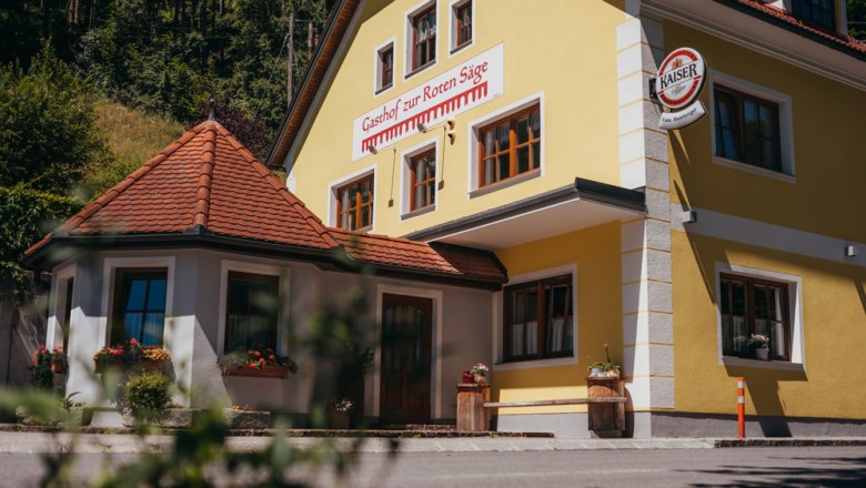Inn in St. Oswald, © Niederösterreich Werbung/Daniela Führer Yellow building with the inscription 'Gasthof zur Roten Säge' and a Kaiser beer sign.