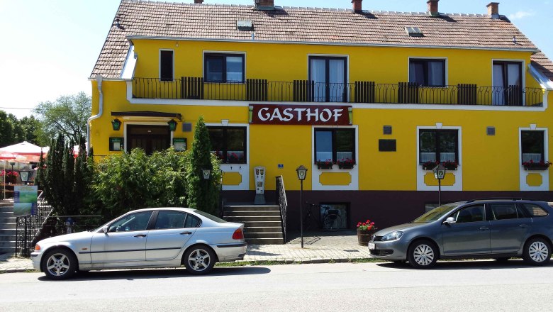 House view, © © GH Prinz Eugen Yellow building with the inscription 'Gasthof', two parked cars in front of it.