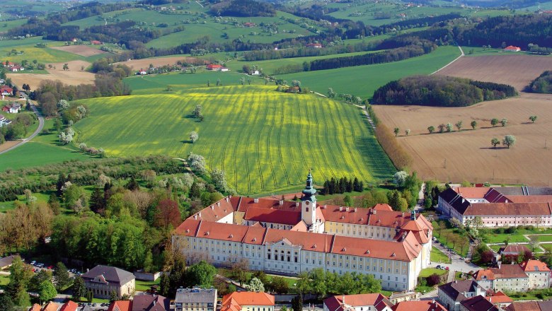 Benedictine Abbey Seitenstetten, © www.stift-seitenstetten.at Aerial view of Seitenstetten Benedictine Abbey surrounded by green fields and hills.